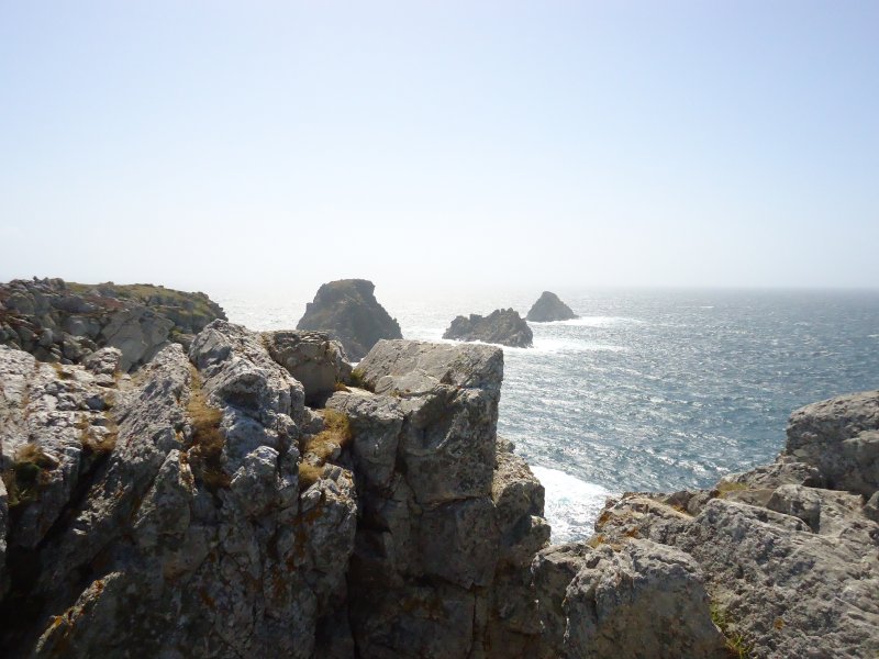 A view from a cliff top with rocks in the foreground looking out to sea