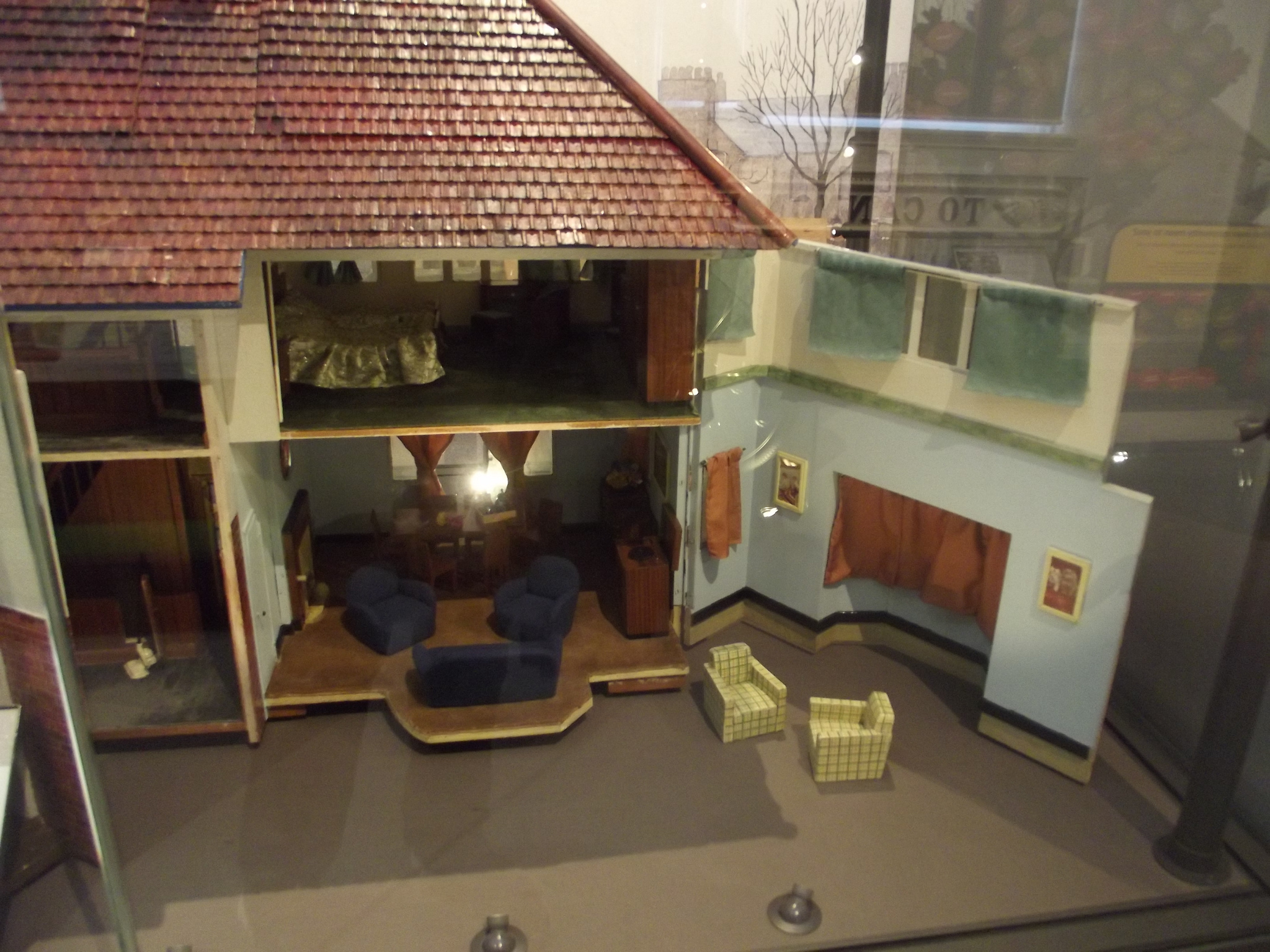 A doll's house with it's front wall opened up to show the contents
