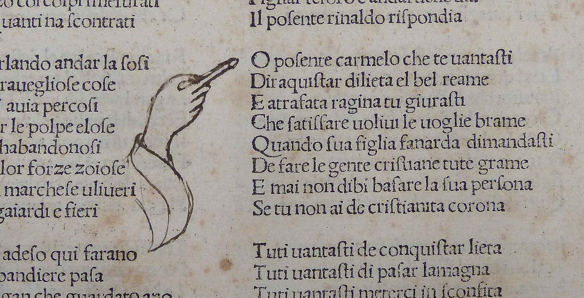 A picture of a book, written in Latin, with a drawn picture of a hand pointing to a paragraph of text
