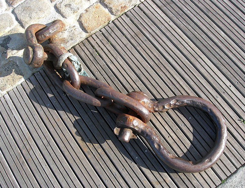 A large shackle on a harbour wall