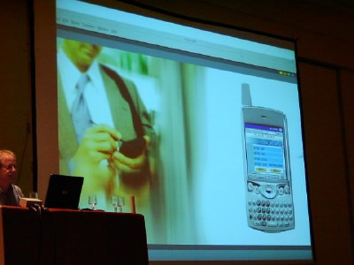 a photo of the screen during phone demo: business man entering data next to a picture of the face of the phone showing the interface to what he is doing