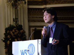 Takeshi Natsuno speaking into microphone on stage