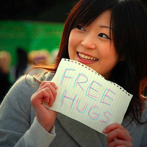 Woman holding free hugs sign