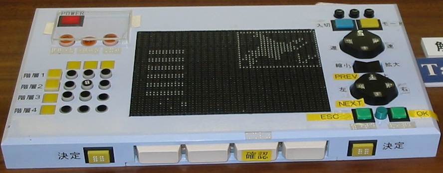 A photograph, from the exhibition at WSIS 2005, of a Japanese dynamic tactile display, which uses refreshable braille cells to form the display area.