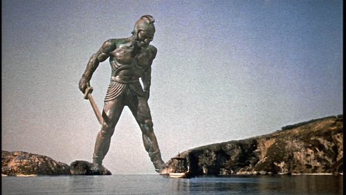 An enormous heroic figure standards astride the Straits of Gibraltar, looking down at a tiny ship