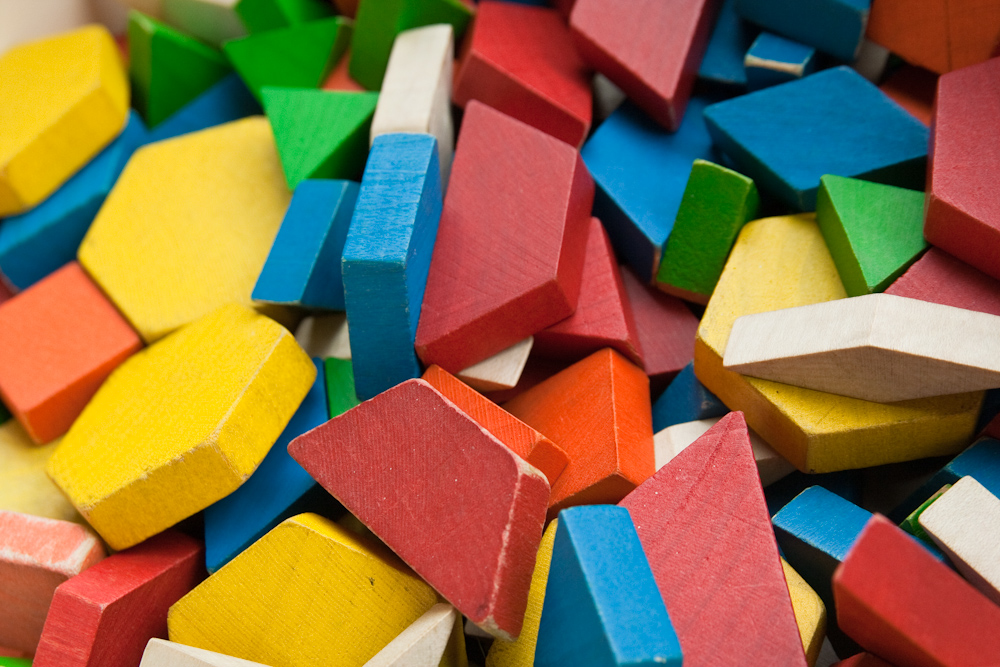 A collection of children's wooden blocks of different sizes, shapes and colours