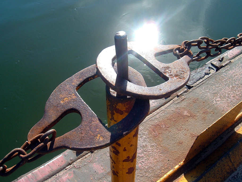 Two chains both meet on a central pillar. Chains appear to be on the edge of a ferry