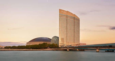 [Photo: dawn view of the Hilton Hotel form the water]