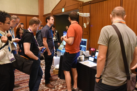 group of TPAC attendees at a demo stand