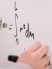 [photo of a hand writing math on a whiteboard]