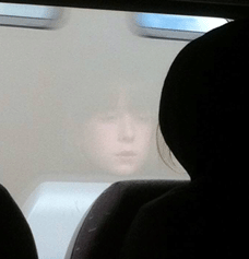 Reflection of a girls face in a train window.