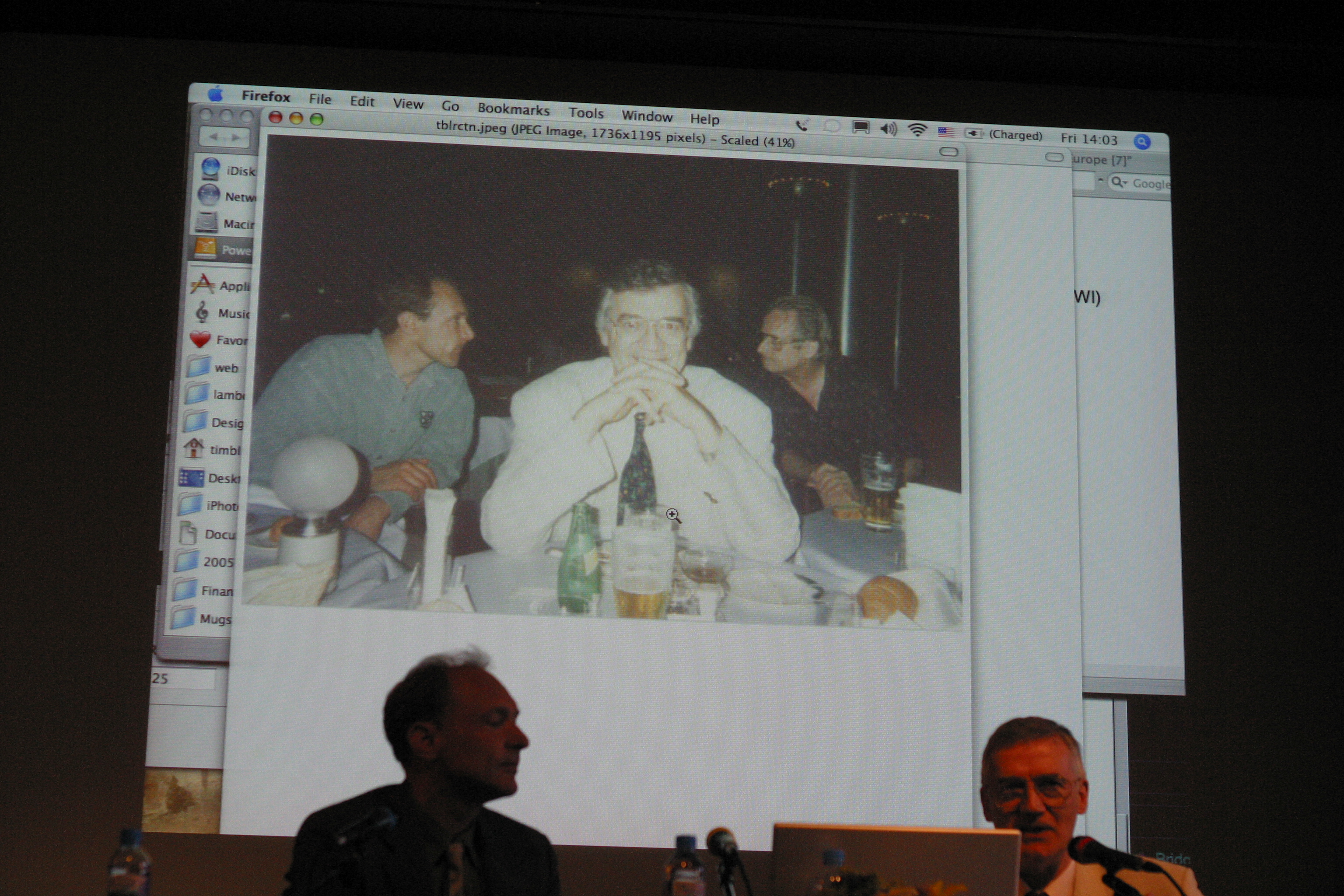 [photo: Tim Berners-Lee and Robert
  Cailliau on a stage in front of a photo of Ted Nelson talking with
  Tim and Robert looking into the camera]